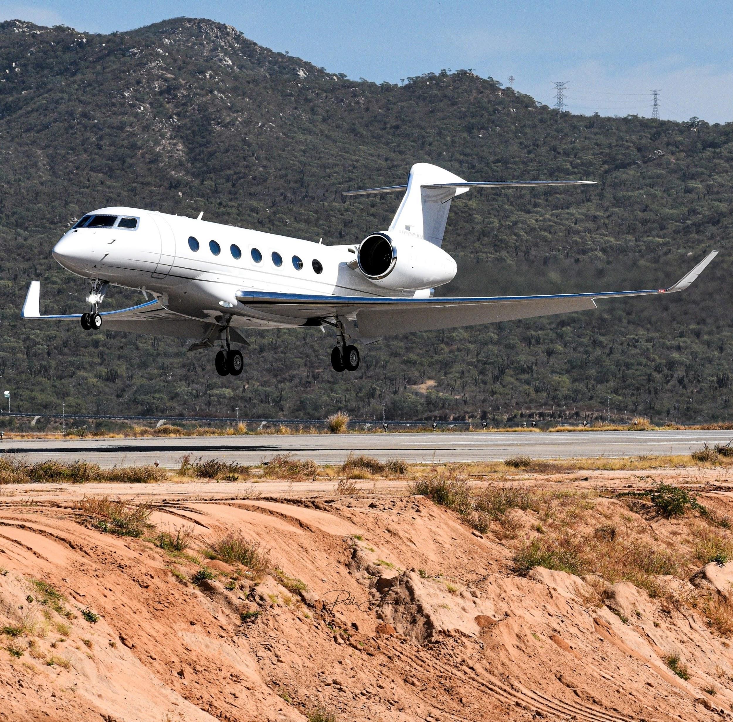 Private jet landing with mountains